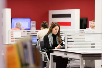 A student sat in shared study space in the library at Pontypridd Campus, Treforest