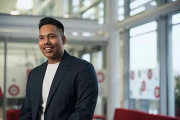 Business and Management student, wearing a suit, smiling.