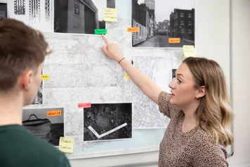 Students looking at evidence stuck to a wall.