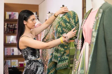 A student altering a garment on a mannequin at the USW Graduate Fashion Week 2019.