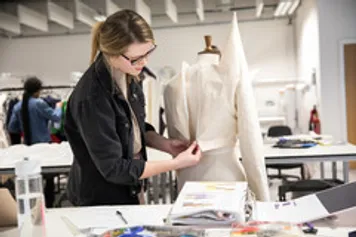 A student is working on a tailors mannequin.