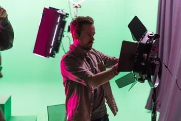 A student is altering studio lighting equipment.