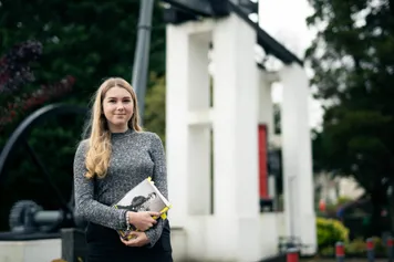 History student smiling into camera, stood outside Ty Crawshay on Treforest campus.