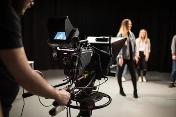 Recording camera being used to film students in a studio