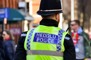 Police office wearing reflective vest with bilingual sign