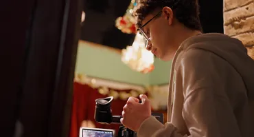 Michael Karam, a Film student looking at a camera