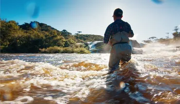 researcher standing in a river fishing