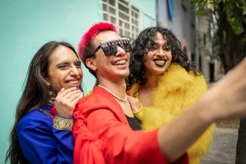 Group of friends using mobile phone to take selfie