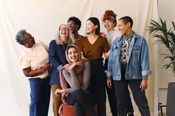 Portrait of cheerful mixed age range multi ethnic women smiling and laughing together