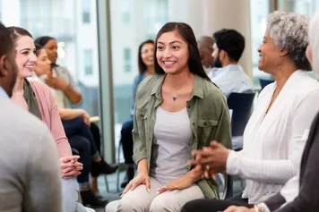 group of people sitting around in a support group talking