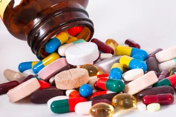A variety of different pills spilled out on to a table