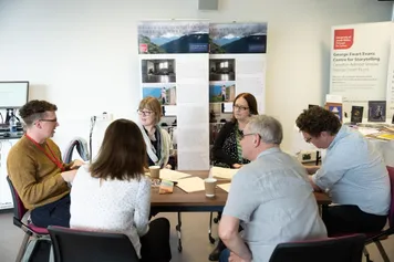 Group of FBCI researchers discussing work at an academic research event in the Zen room at Cardiff campus