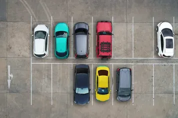 areal shot of 8 cars in a car park