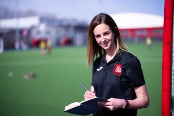 A PhD student standing with their work at the Sports Park