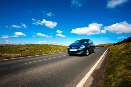 A car speeds by on a country road.
