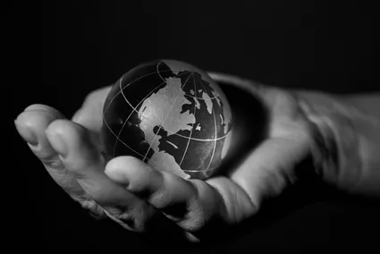 black and white photograph of a hand holding a small globe