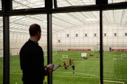 Onlooker analysing a football game at the University Sport Park.