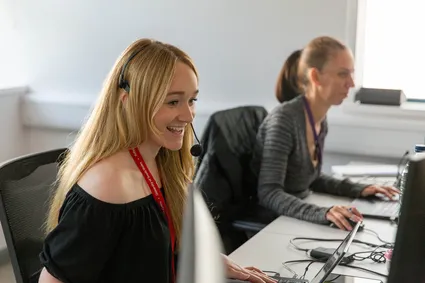 two members of university staff working on the phone lines during clearing