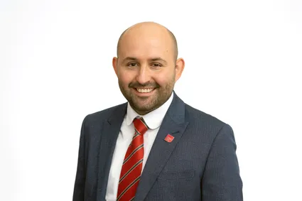 A professional photograph of James Gravelle smiling at the camera.