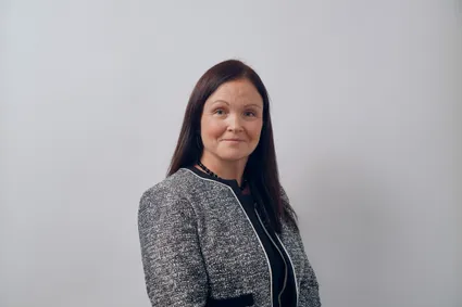 A profressional photograph of Rachel Elias-lee smiling at the camera.