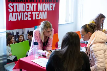 Member of the student money advice team supporting a parent and prospective student at an open day
