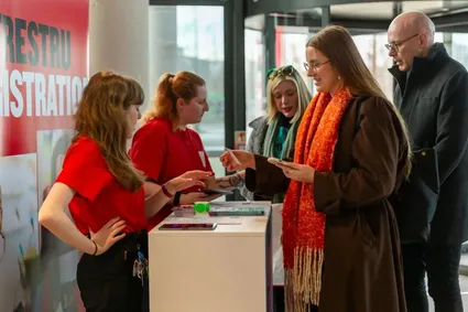 USW staff at a stand at the Postgraduate open evening talking to potential students