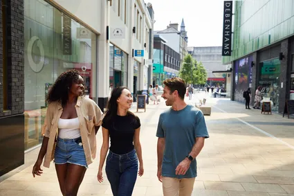 Three friends browsing the shops in Friars Walk Newport.
