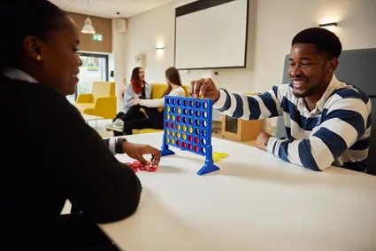 Students playing a game of connect 4 in the accommodation hub.