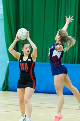 A student is trying to pass the ball but is being blocked by the other team.