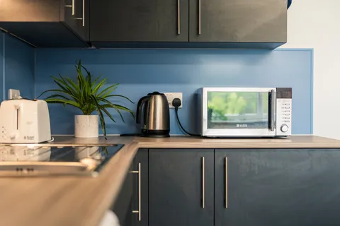 A close up of a kettle, microwave, and toaster at a Pontypridd accommodation block.