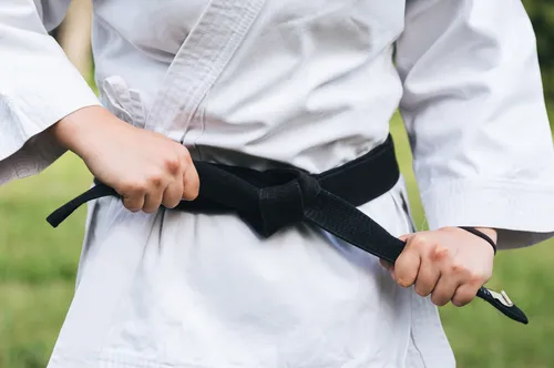 Female fighter tightening karate belt