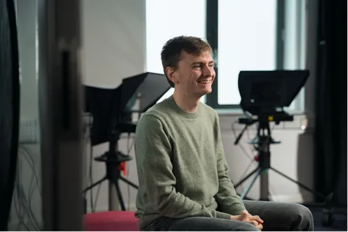 Student sits smiling just off from the camera