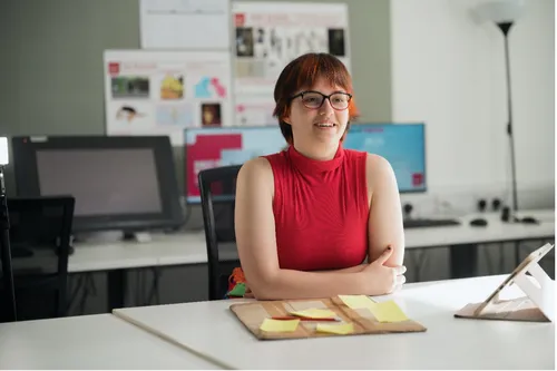 Oliwia sat behind a desk smiling at the camera