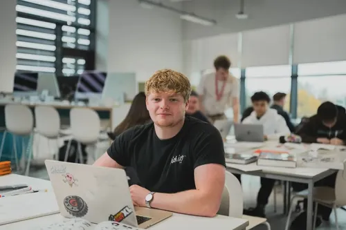 Student sat at a desk working on a laptop