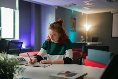 Student Lucy making notes whilst sat a desk