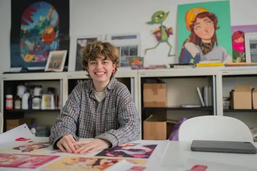 Illustration student smiling, looking away from the camera, whilst working on a project