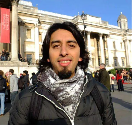 MA Animation student Mario Quinones smiling while dressed in a winter coat and scarf, and standing in front of The National Gallery in London