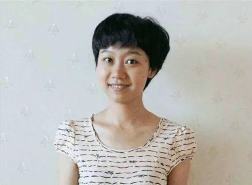 MBA student Zhou Wenxin smiles at the camera in front of a white background
