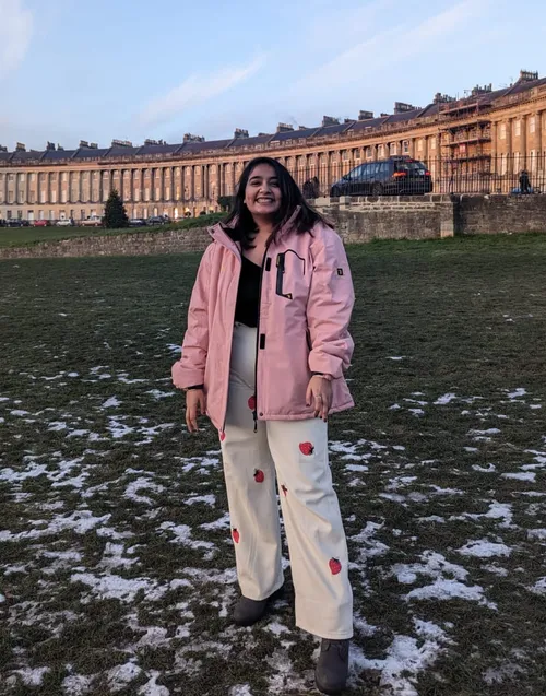 A photo of Pratiksha smiling at the camera in front of The Crescent, in Bath, England
