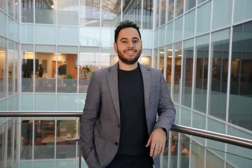 Computing graduate, Hamed, poses for a photo in his workplace