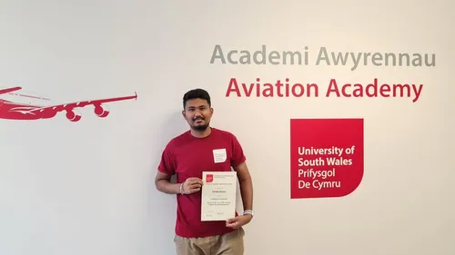 Shubh smiles at camera whilst produly holding a certificate