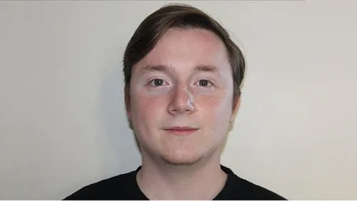 Drama student, Tom, takes a selfie against a white wall