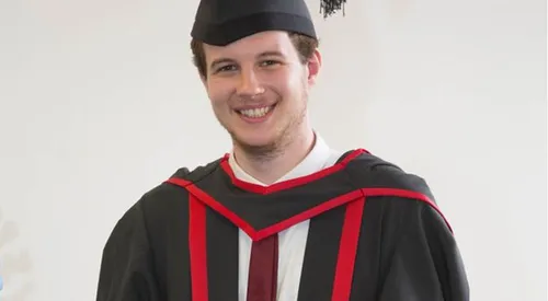 Graduate Jack wearing his graduation cap and robe