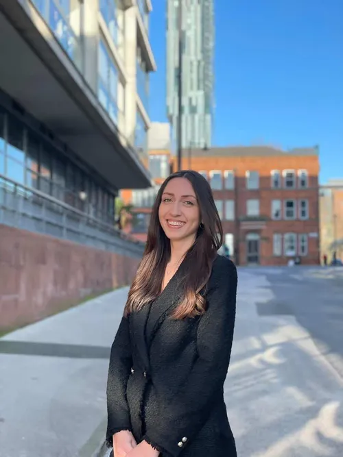 Alumni Amira stood in front of an office building