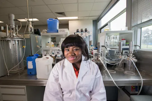 Dr Morley Muse wearing a lab coat and sitting in a science lab.