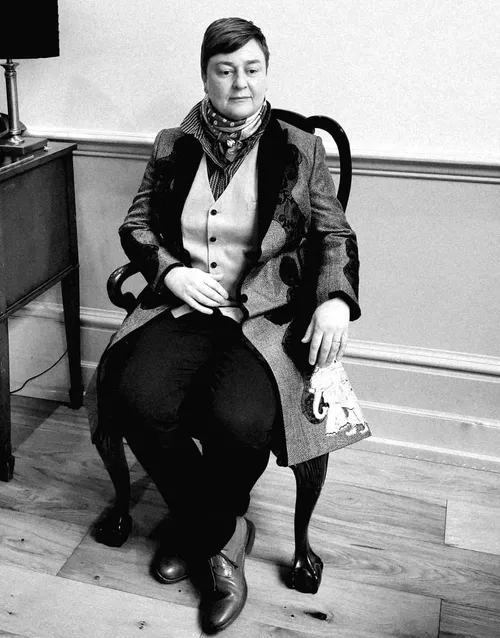 USW alumni Rachel Dax poses for a photo in an arm chair