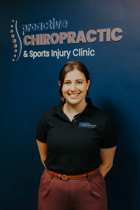 Women smiling in front of Chiropractic sign