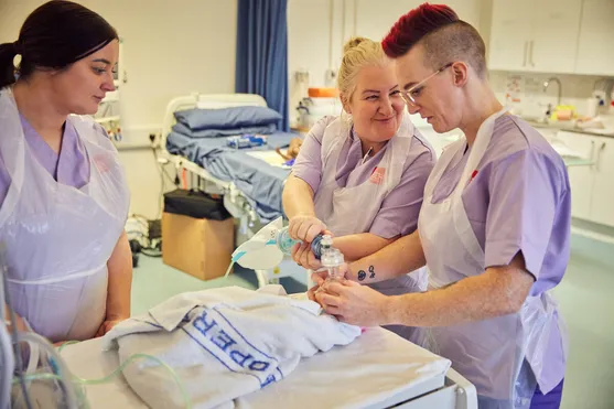 Midwifery students in a ward setting with a patient simulator.