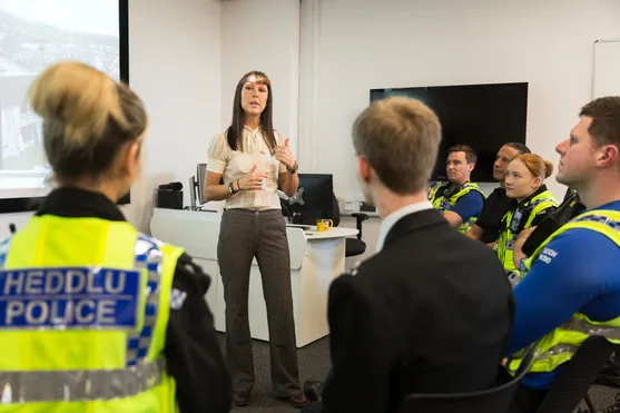 An academic presents to a room full of students and police officers in a classroom
