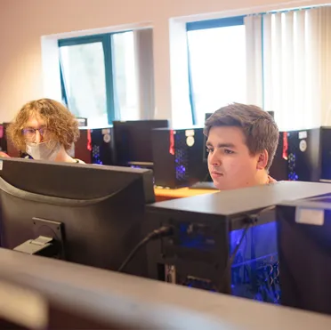 Computer science students concentrate while working at desktop PCs in a USW Computer Science workshop at USW Treforest